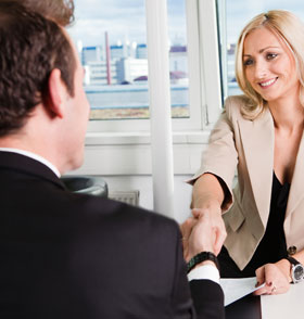 Photo over the shoulder of a man shaking hands with a woman